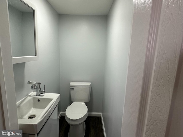 bathroom with vanity, toilet, and hardwood / wood-style floors