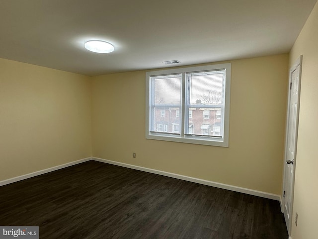 unfurnished room with dark wood-type flooring