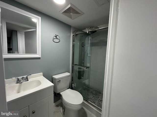 bathroom featuring vanity, an enclosed shower, and toilet