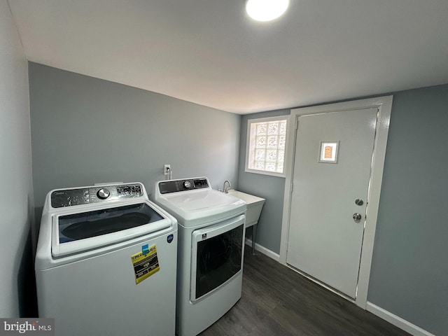 laundry room with dark hardwood / wood-style flooring, separate washer and dryer, and sink