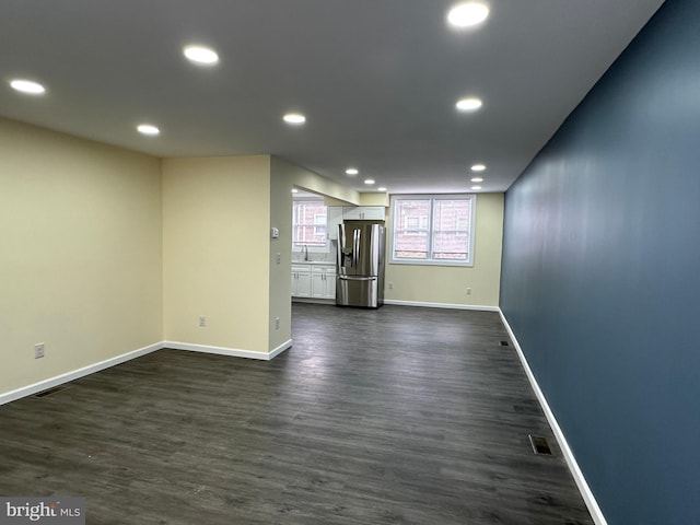 unfurnished living room with sink and dark hardwood / wood-style floors