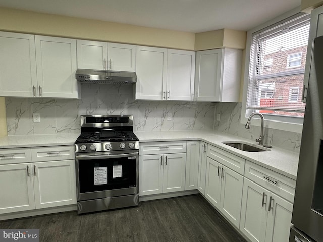 kitchen featuring stainless steel gas range oven, sink, dark wood-type flooring, and white cabinets