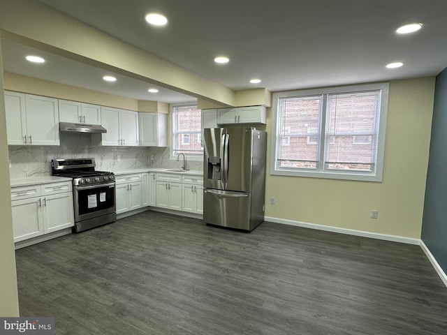 kitchen featuring dark wood-type flooring, sink, white cabinetry, appliances with stainless steel finishes, and backsplash