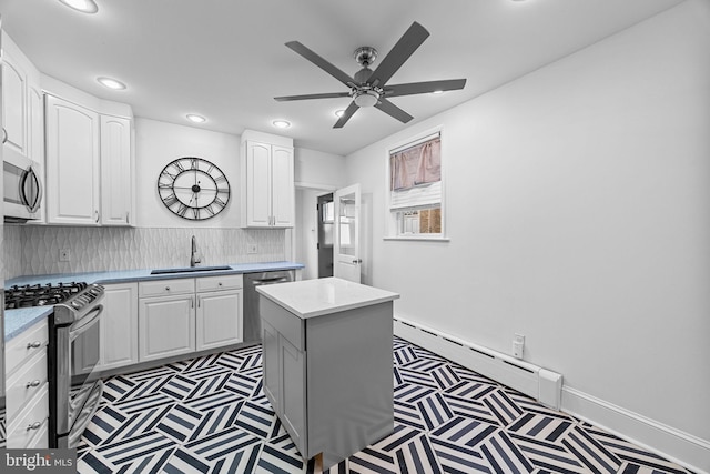 kitchen with a kitchen island, appliances with stainless steel finishes, sink, and white cabinets