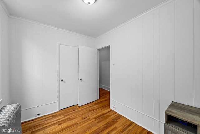 bedroom featuring ornamental molding and light wood-type flooring