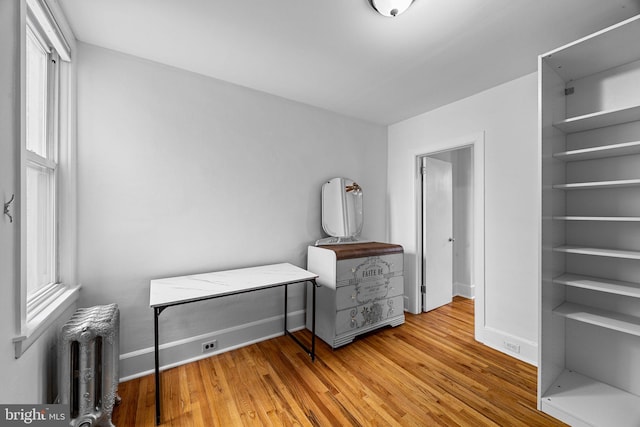 bedroom with hardwood / wood-style flooring and radiator heating unit