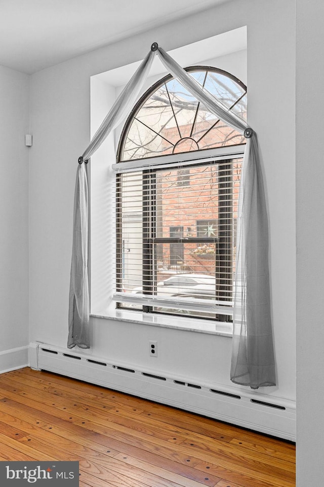 details featuring baseboard heating and hardwood / wood-style flooring