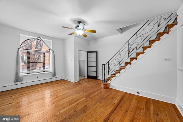 interior space with a baseboard heating unit, hardwood / wood-style floors, and ceiling fan