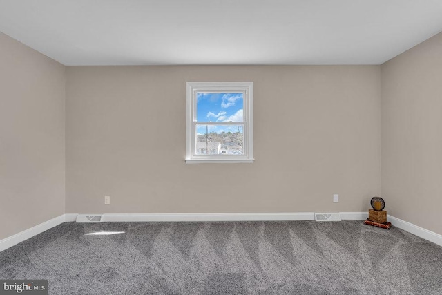 spare room featuring carpet, visible vents, and baseboards