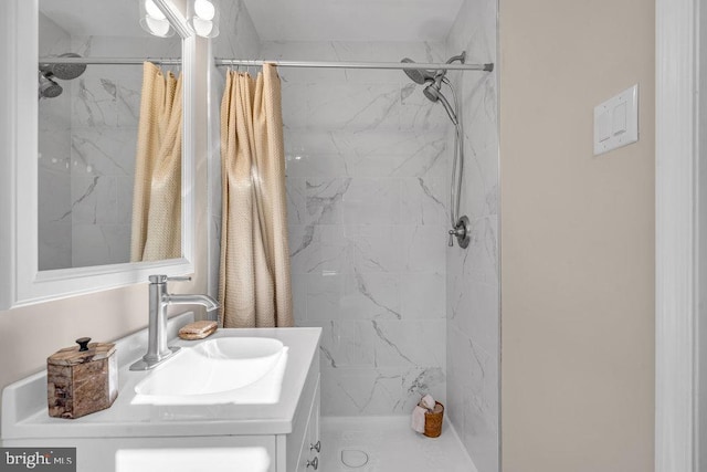 full bath with a marble finish shower and vanity