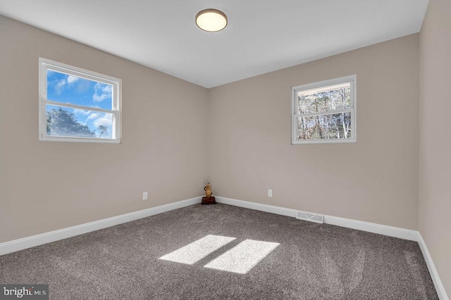 unfurnished room featuring carpet floors and baseboards