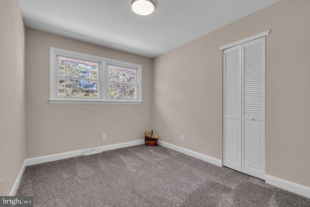 unfurnished bedroom with carpet, baseboards, and a closet