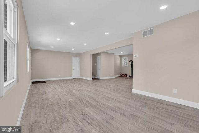 unfurnished living room with recessed lighting, light wood-type flooring, visible vents, and baseboards