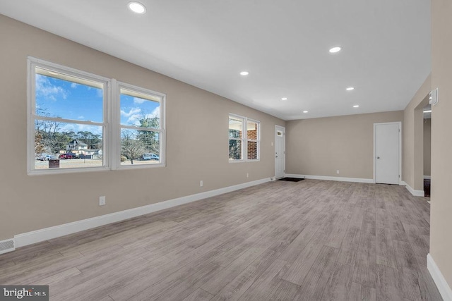 spare room featuring light wood finished floors, recessed lighting, and baseboards