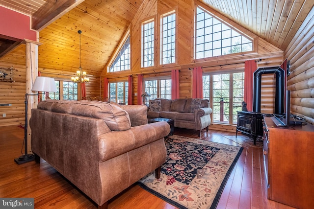 living room with a chandelier, wooden ceiling, a wood stove, and hardwood / wood-style floors