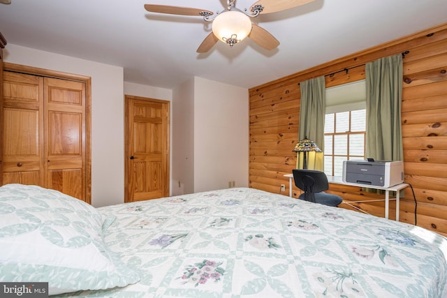 bedroom featuring a closet, rustic walls, and ceiling fan