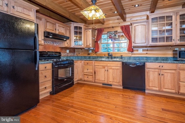 kitchen featuring dark countertops, under cabinet range hood, wooden ceiling, black appliances, and a sink