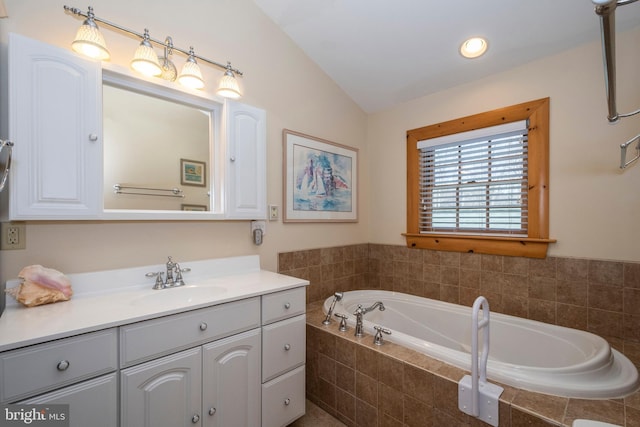 bathroom with a bath, vanity, and vaulted ceiling