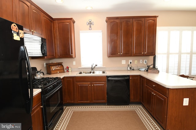 kitchen featuring sink, kitchen peninsula, and black appliances