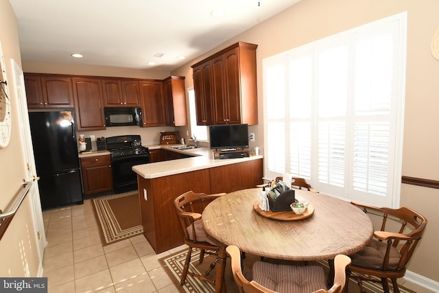 kitchen with light tile patterned floors, sink, black appliances, and kitchen peninsula