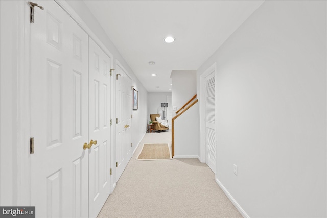 corridor with recessed lighting, light colored carpet, and baseboards