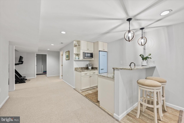 kitchen with light stone counters, open shelves, recessed lighting, stainless steel microwave, and white cabinets