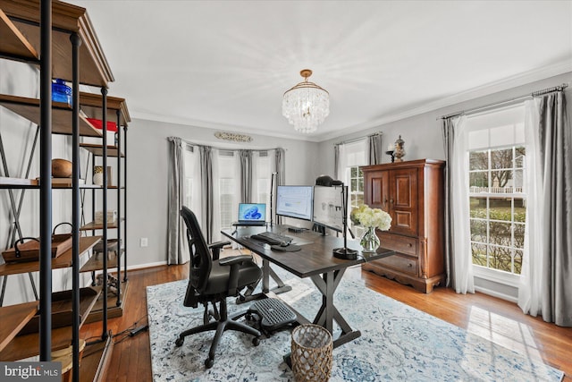 office area with baseboards, ornamental molding, wood finished floors, and a notable chandelier