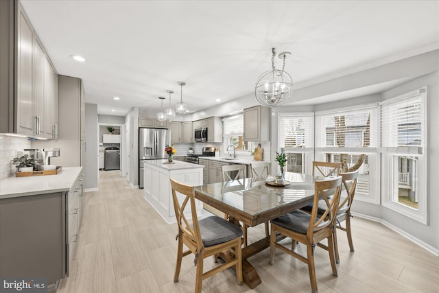 dining area with a chandelier, recessed lighting, washer / clothes dryer, and baseboards