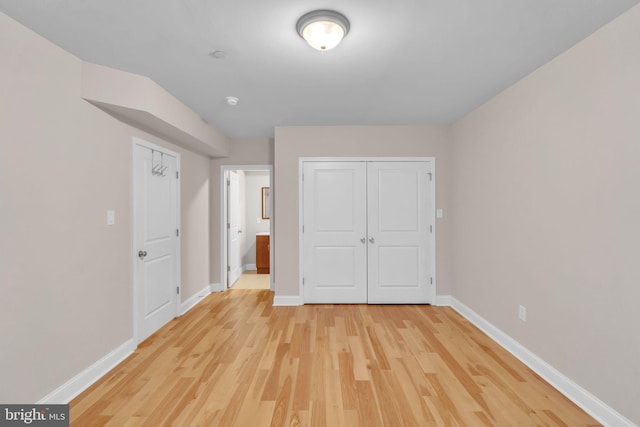 unfurnished bedroom featuring a closet and light wood-type flooring