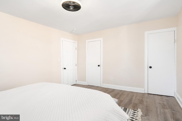 bedroom with light wood-type flooring and baseboards