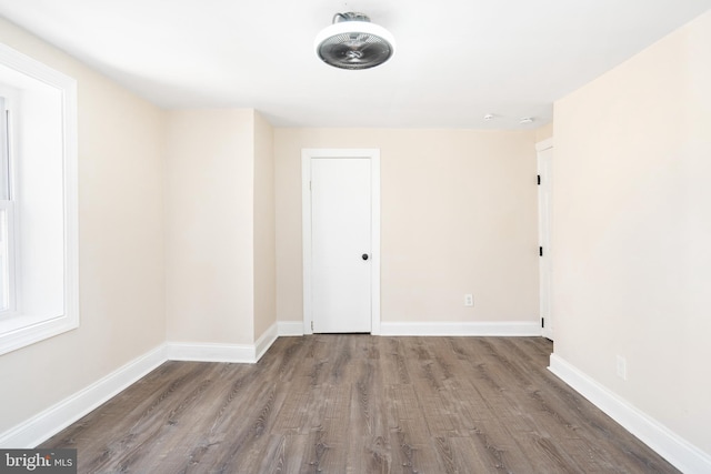 unfurnished room featuring dark wood-style flooring and baseboards