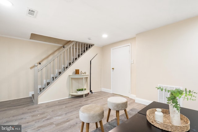 living area featuring stairway, visible vents, and wood finished floors