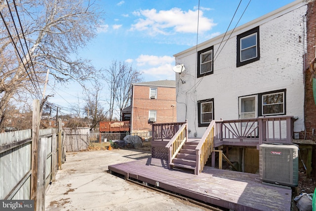 back of house with a deck, central AC unit, a fenced backyard, brick siding, and stairs