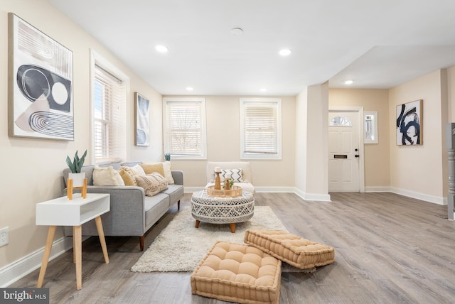 living area with light wood finished floors, baseboards, and recessed lighting