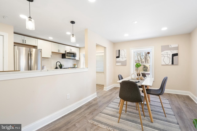 dining area with baseboards, recessed lighting, and light wood-style floors