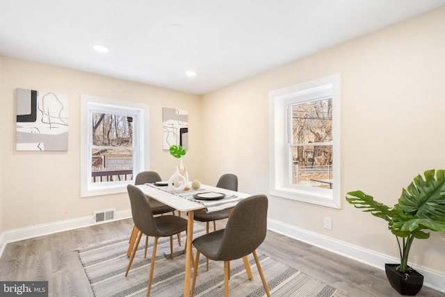 dining area featuring baseboards, visible vents, and wood finished floors