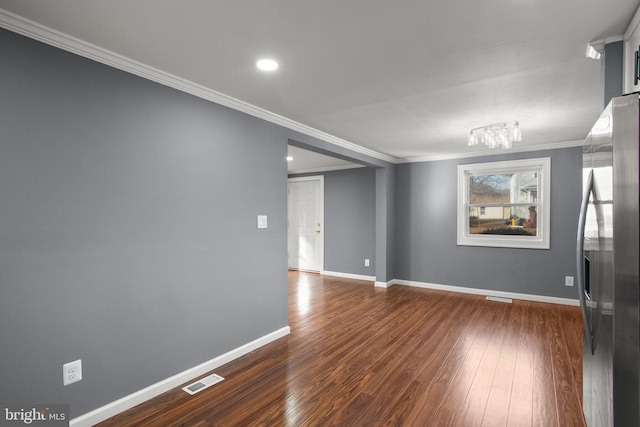 spare room with dark wood-type flooring and ornamental molding