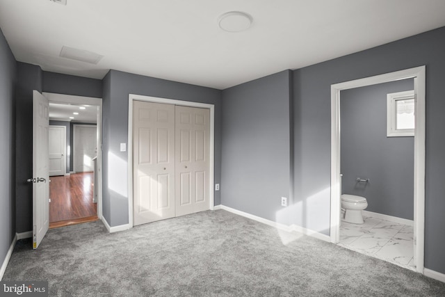 unfurnished bedroom with connected bathroom, light colored carpet, and a closet