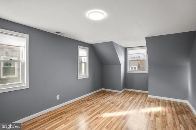 additional living space featuring lofted ceiling and light hardwood / wood-style floors