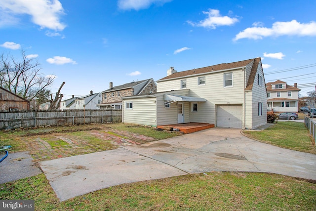 back of house featuring a garage and a lawn