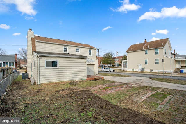 back of house featuring a garage and central air condition unit