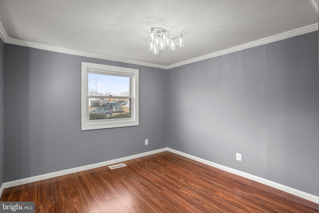 spare room with crown molding, wood-type flooring, and an inviting chandelier