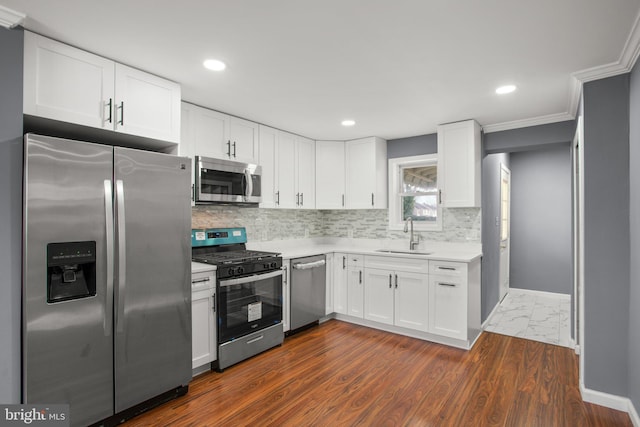 kitchen with sink, stainless steel appliances, white cabinets, dark hardwood / wood-style flooring, and decorative backsplash