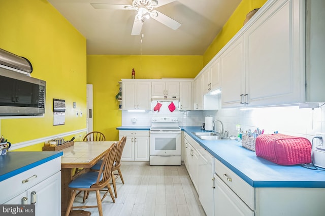 kitchen with white electric range, a sink, white cabinetry, and under cabinet range hood