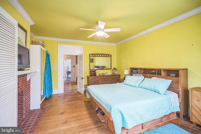 bedroom with baseboards, a ceiling fan, crown molding, and wood finished floors