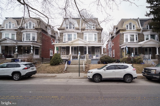 view of front of property with a porch and mansard roof