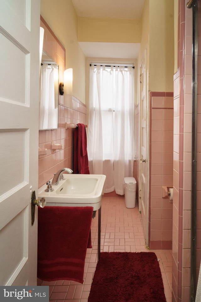 full bath featuring a wainscoted wall, tile patterned flooring, tile walls, and vanity