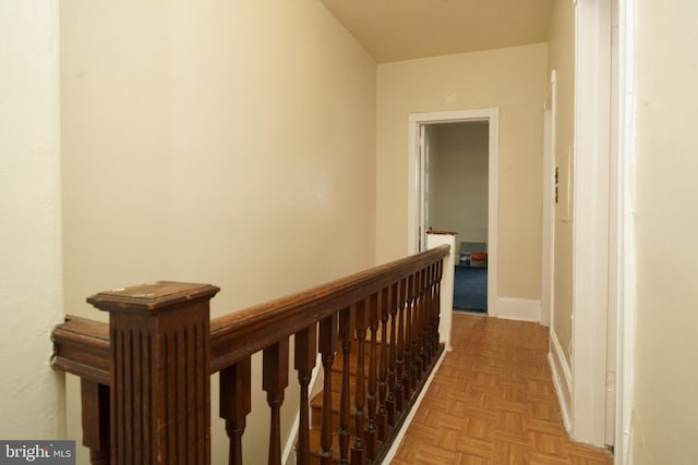 hall with baseboards and an upstairs landing