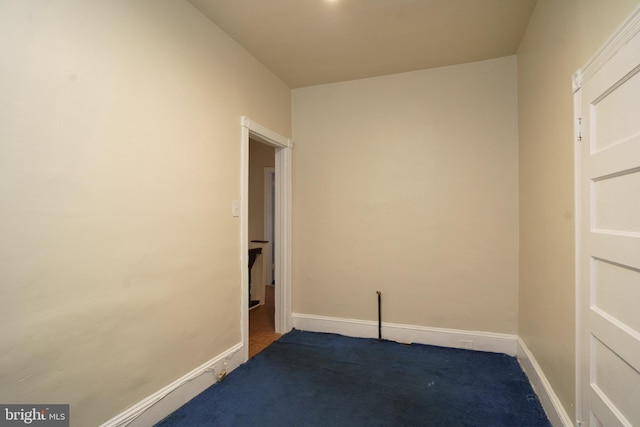 spare room featuring carpet floors and baseboards