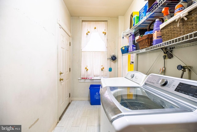 washroom with laundry area, washer and clothes dryer, and wood finished floors